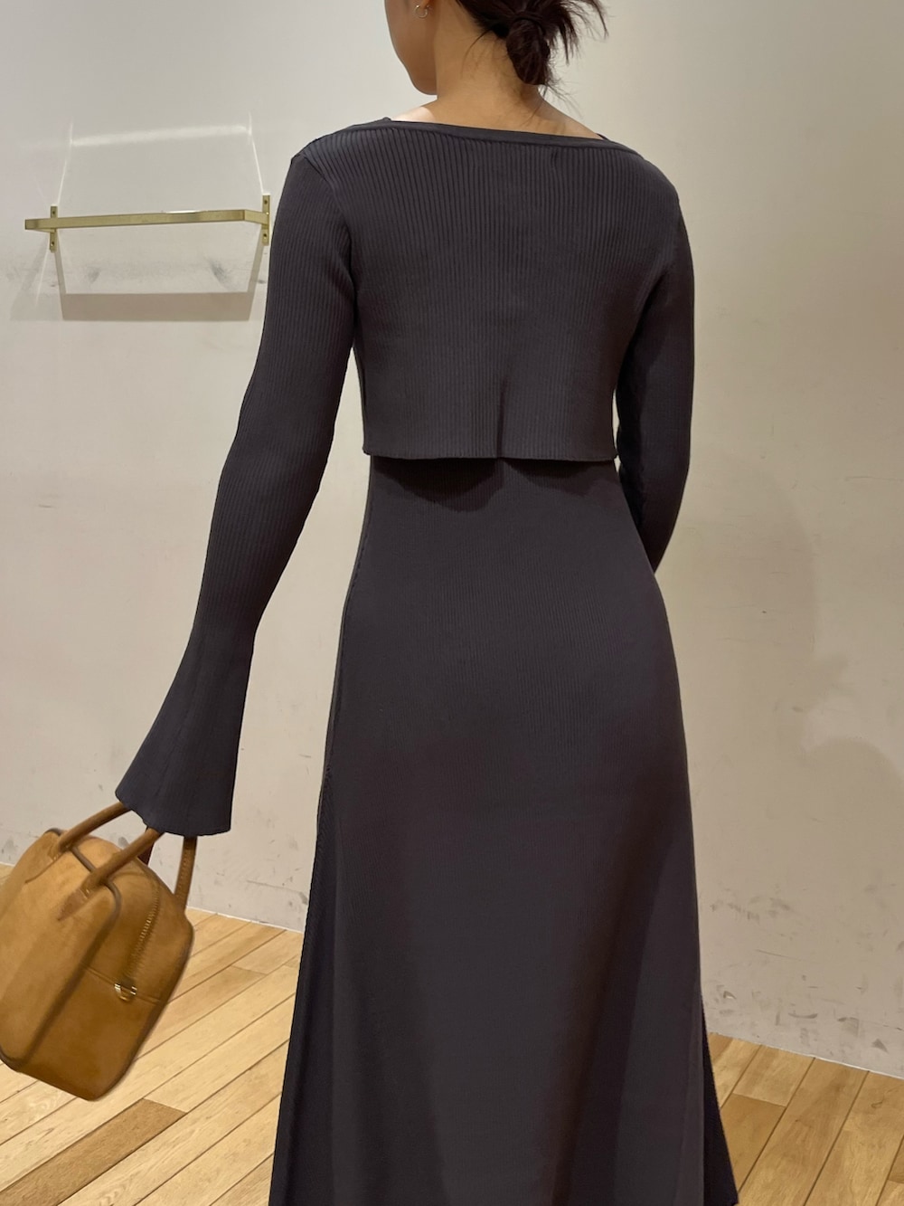 ブラック系のブーツ、グレー系のワンピース、ブラウン系のハンドバッグを着用したレディースの秋コーディネートの7枚目の写真