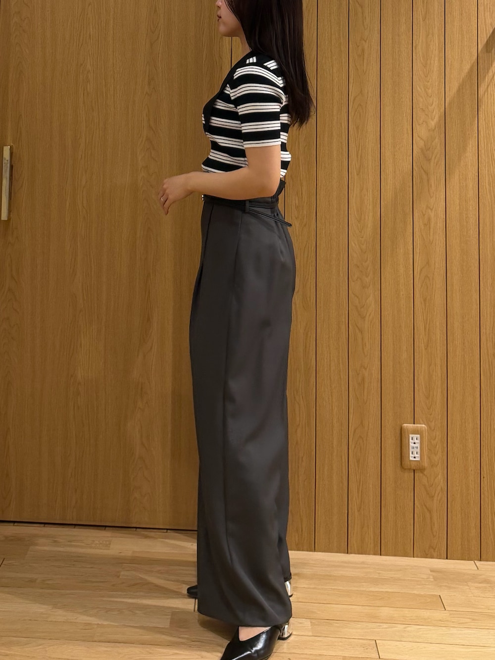 グレー系のその他パンツ、ブラック系のニット/セーター、ブラック系のパンプスを着用したレディースの春コーディネートの2枚目の写真