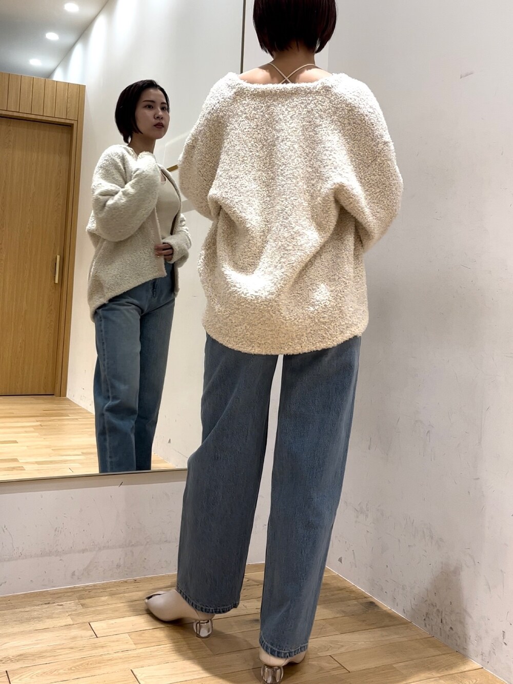 ホワイト系のパンプス、ブルー系のデニムパンツ、ホワイト系のニット/セーターを着用したレディースの冬コーディネートの3枚目の写真