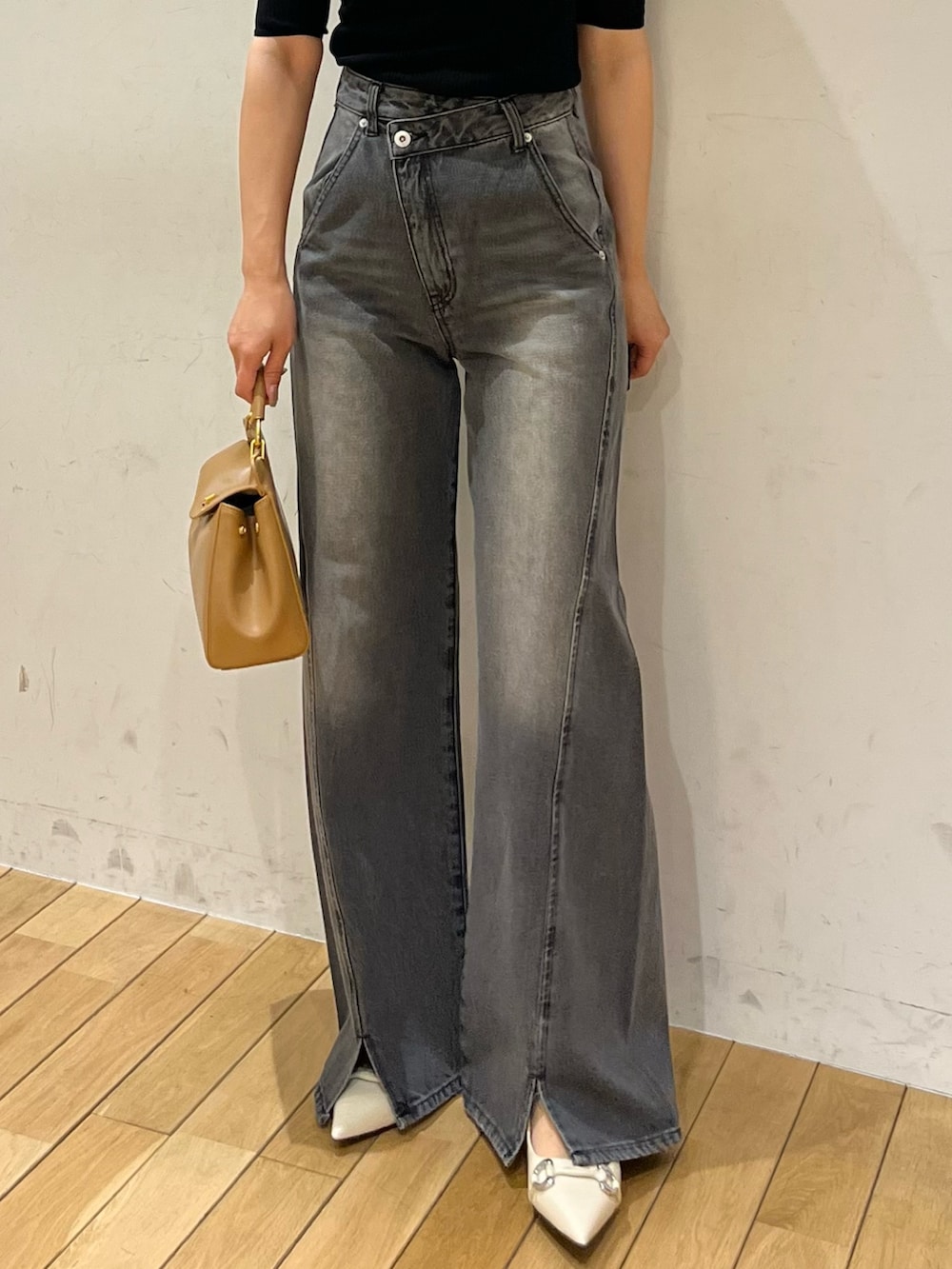 ブラック系のニット/セーター、ブラック系のデニムパンツ、ブラウン系のハンドバッグを着用したレディースの春コーディネートの4枚目の写真