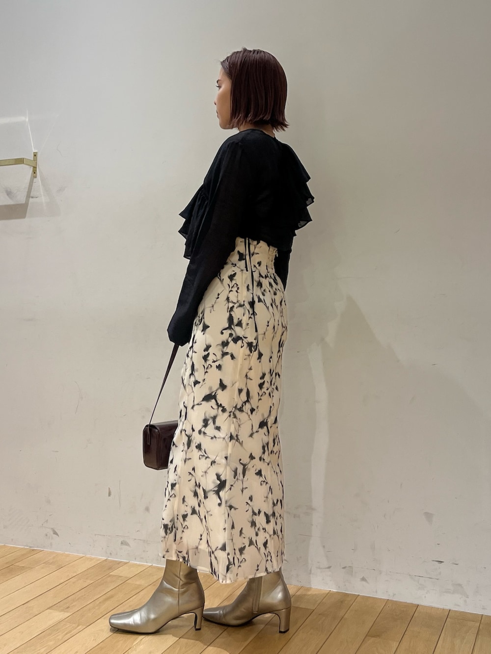 ホワイト系のスカート、レッド系のショルダーバッグ、ブラック系のシャツ/ブラウスを着用したレディースの秋コーディネートの2枚目の写真