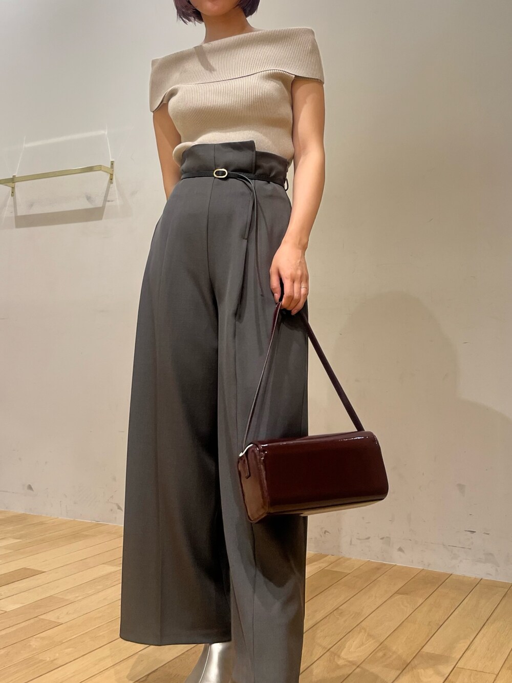 レッド系のショルダーバッグ、ベージュ系のニット/セーター、シルバー系のブーツを着用したレディースの秋コーディネートの5枚目の写真