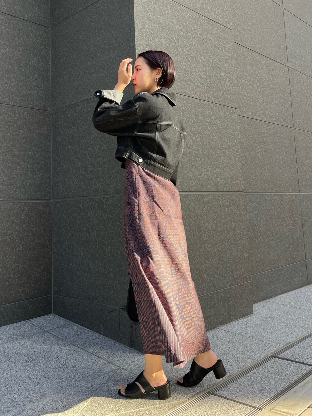 ブラック系のハンドバッグ、ブルー系のワンピース、ブラック系のサンダルを着用したレディースの春コーディネートの2枚目の写真