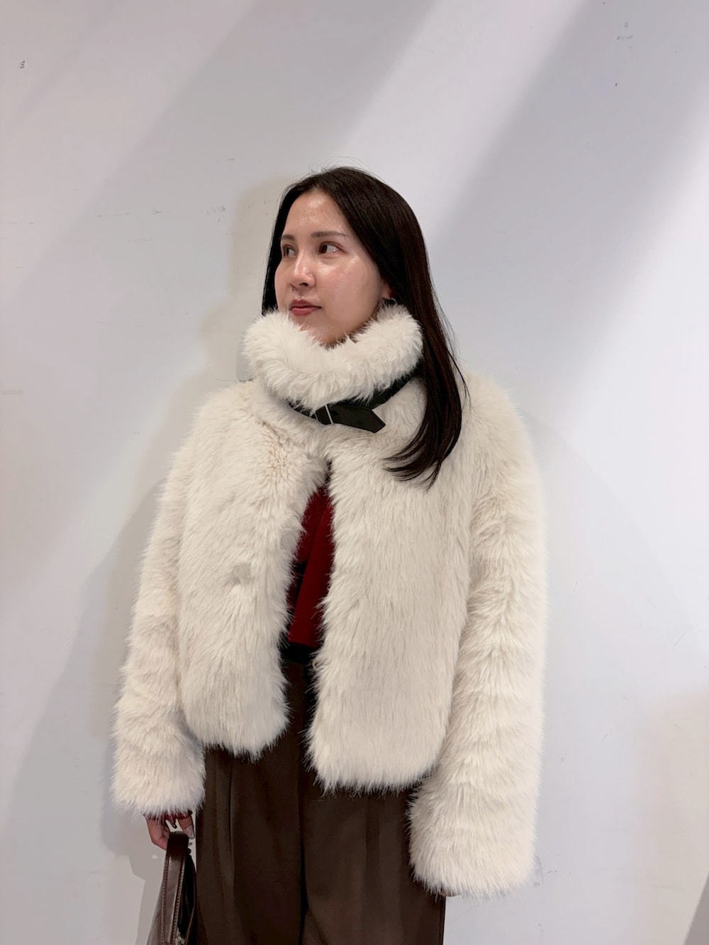 ブラウン系のその他パンツ、レッド系のニット/セーター、ホワイト系のその他アウターを着用したレディースの夏コーディネートの6枚目の写真