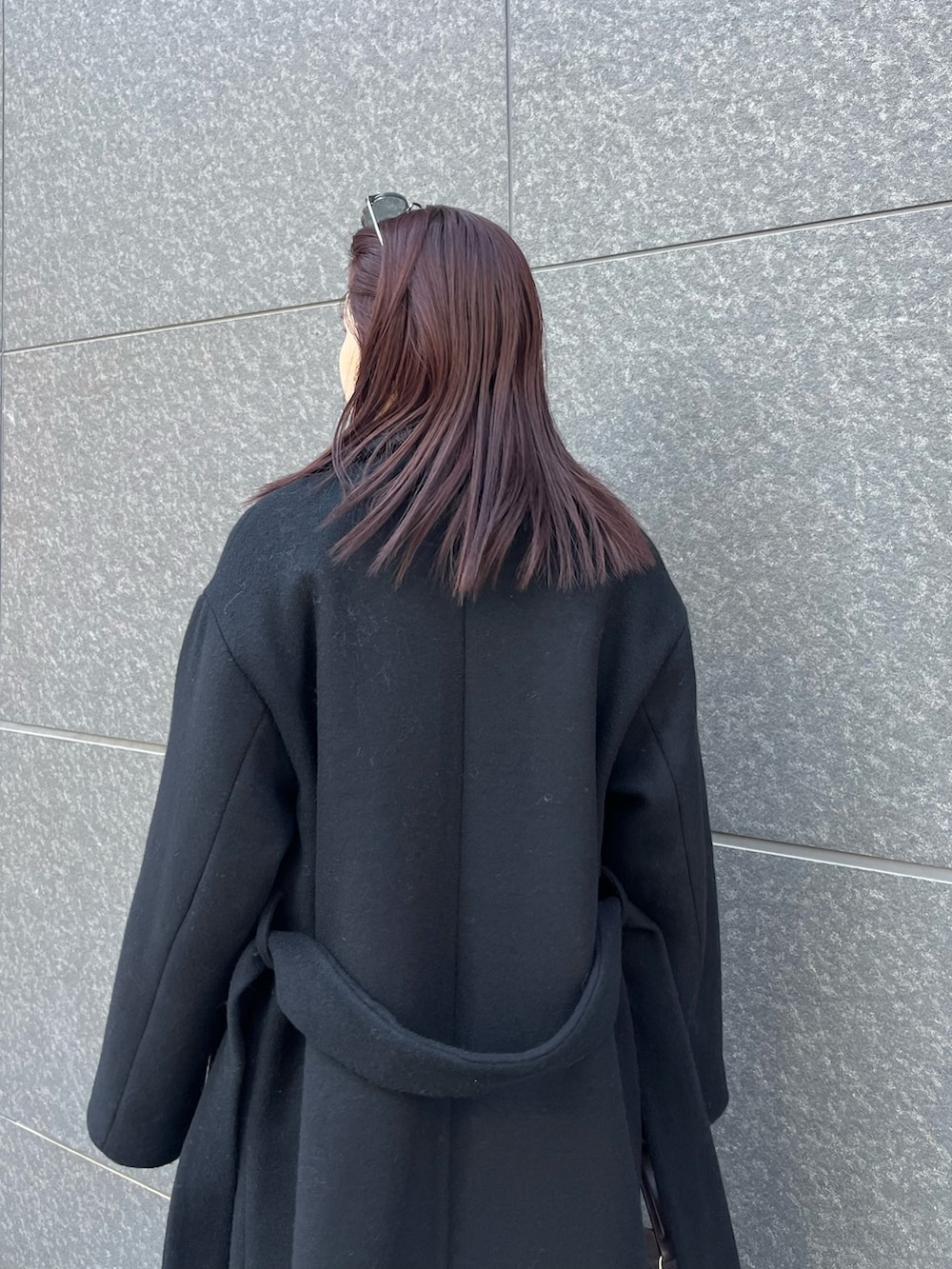 ブルー系のデニムパンツ、ブラウン系のハンドバッグ、ブラック系のブーツを着用したレディースの秋コーディネートの6枚目の写真