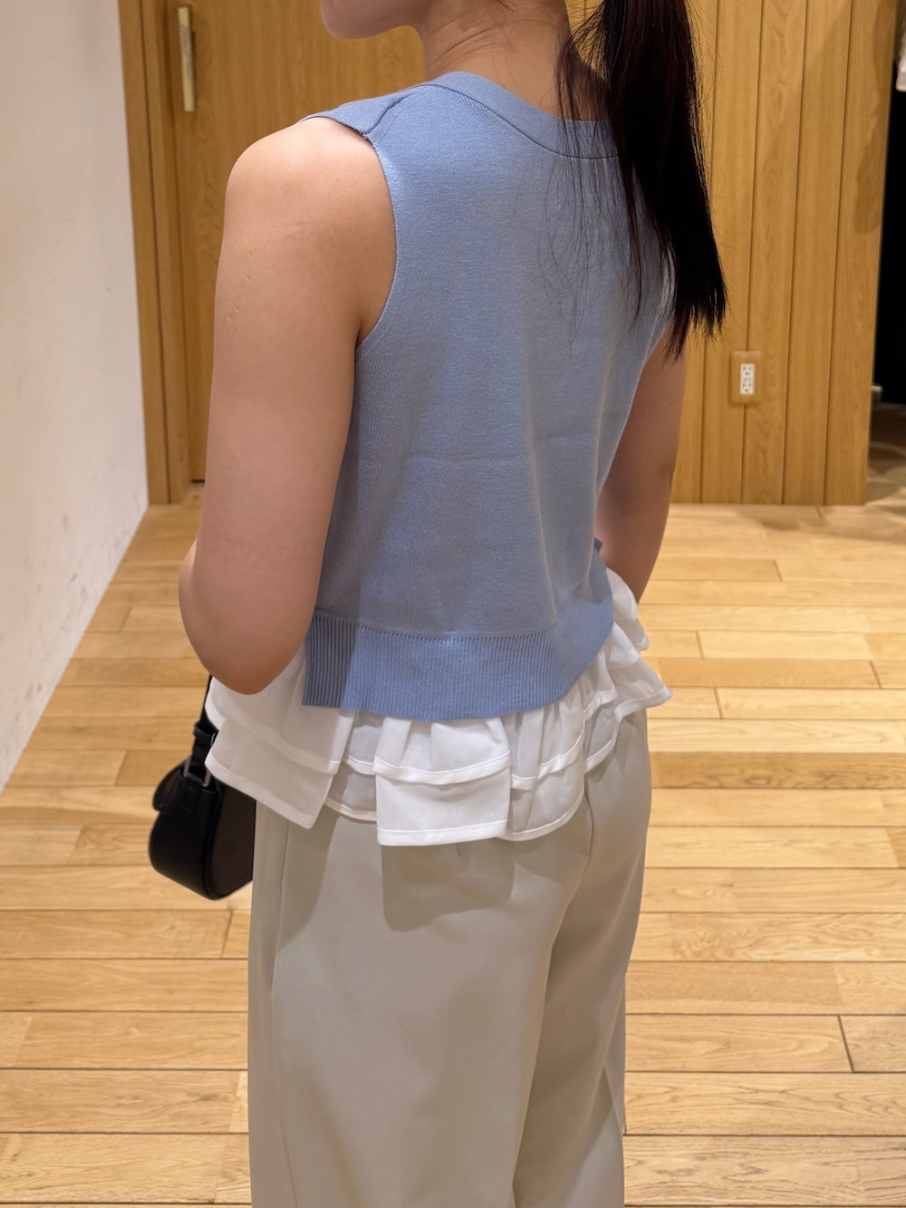 ホワイト系のその他パンツ、ブラック系のパンプス、ブラック系のハンドバッグを着用したレディースの夏コーディネートの5枚目の写真