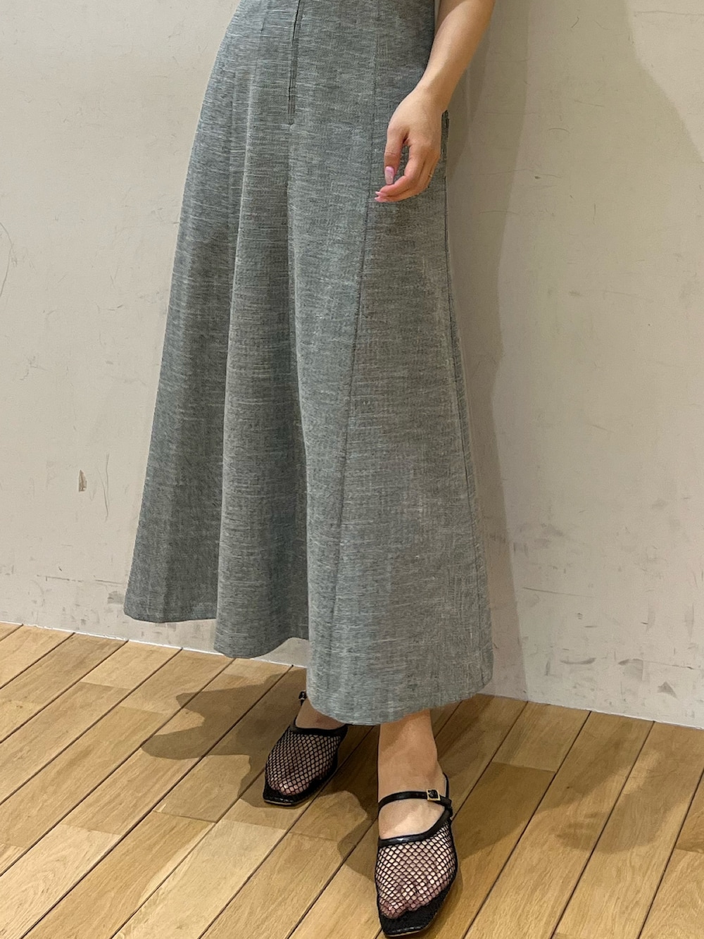 ブルー系のニット/セーター、ブラック系のサンダル、グリーン系のジャンパースカートを着用したレディースの春コーディネートの5枚目の写真