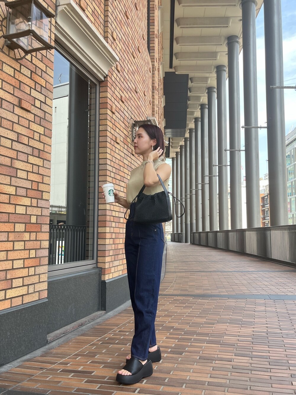 グリーン系のシャツ/ブラウス、ブルー系のデニムパンツ、ベージュ系のハンドバッグを着用したレディースの夏コーディネートの5枚目の写真