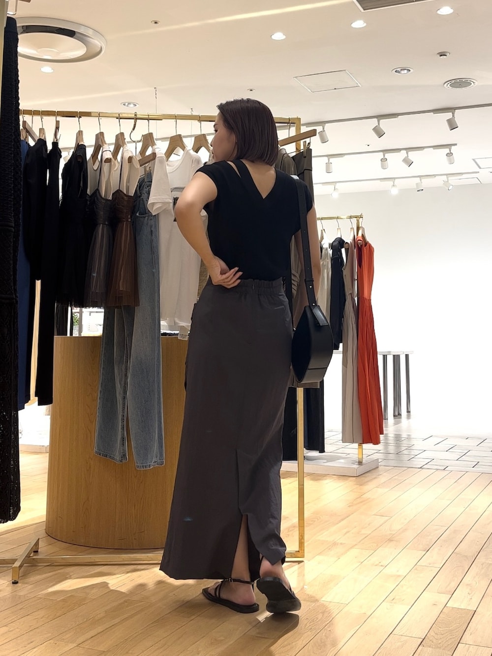 ブラック系のサンダル、ブラック系のショルダーバッグ、グレー系のスカートを着用したレディースの夏コーディネートの3枚目の写真