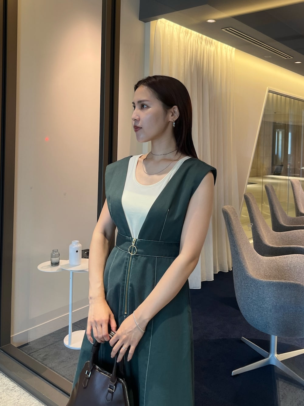 ブラウン系のパンプス、ブラウン系のボストンバッグ、ホワイト系のTシャツ/カットソーを着用したレディースの夏コーディネートの4枚目の写真