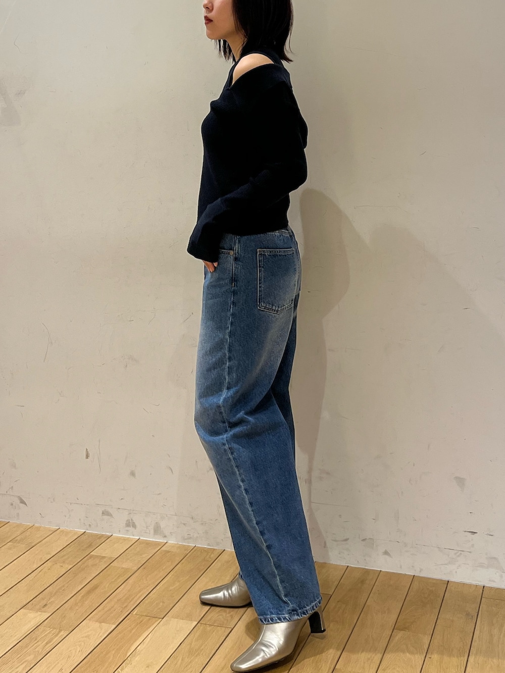 ブルー系のデニムパンツ、ブルー系のアンサンブル、シルバー系のブーツを着用したレディースの冬コーディネートの2枚目の写真