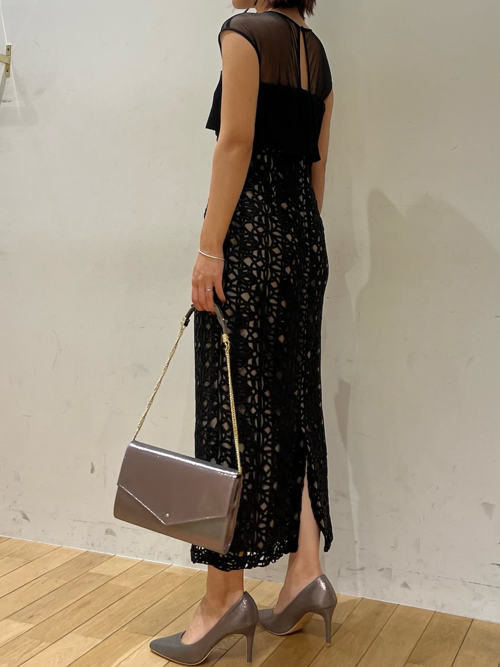 ブラック系のドレス、シルバー系のハンドバッグ、シルバー系のパンプスを着用したレディースの秋コーディネートの2枚目の写真