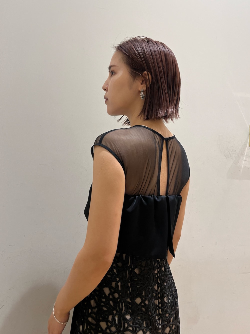 ブラック系のドレス、シルバー系のハンドバッグ、シルバー系のパンプスを着用したレディースの秋コーディネートの5枚目の写真