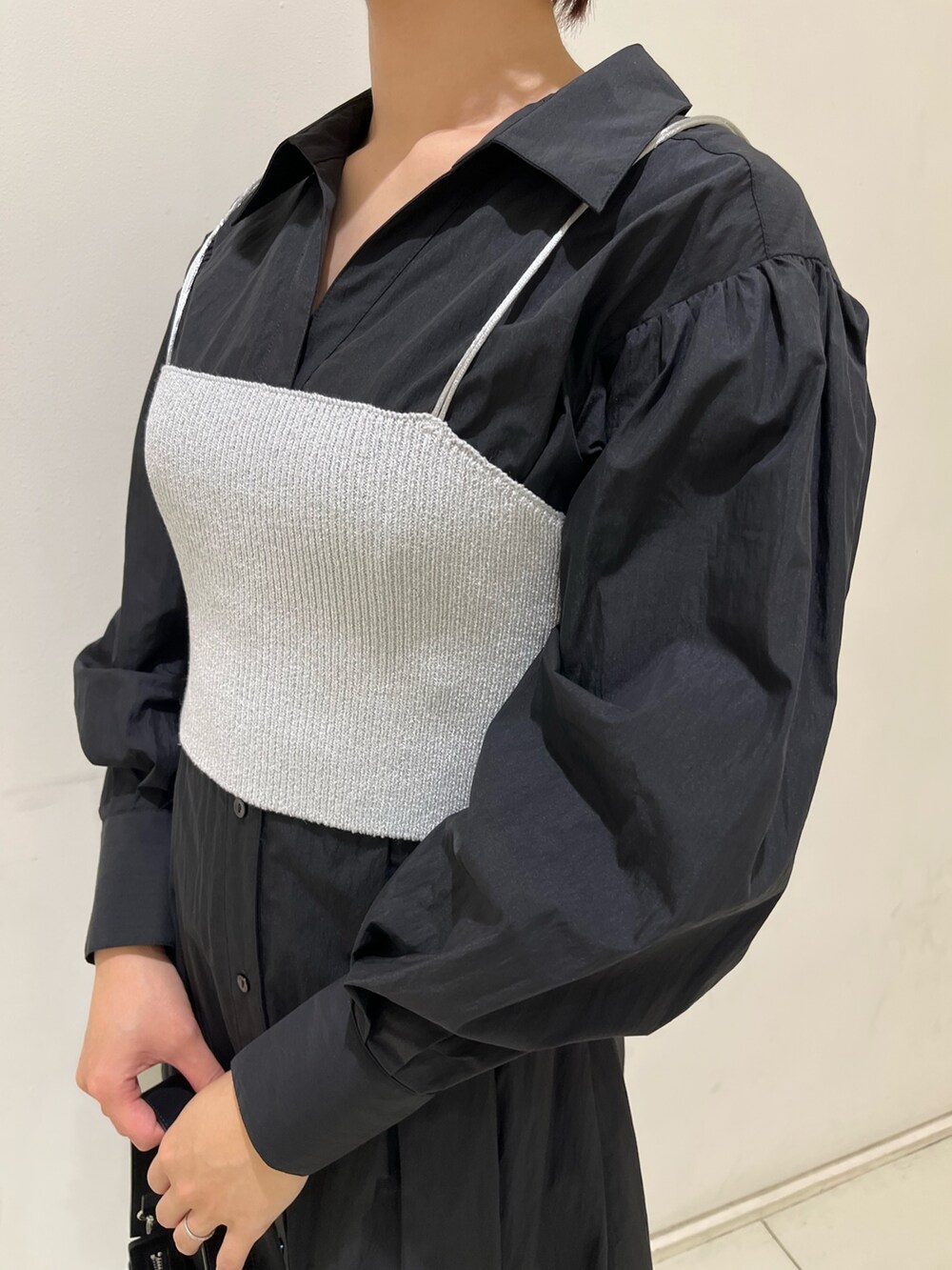 ブラック系のシャツワンピース、ブラック系のハンドバッグ、シルバー系のパンプスを着用したレディースの冬コーディネートの5枚目の写真