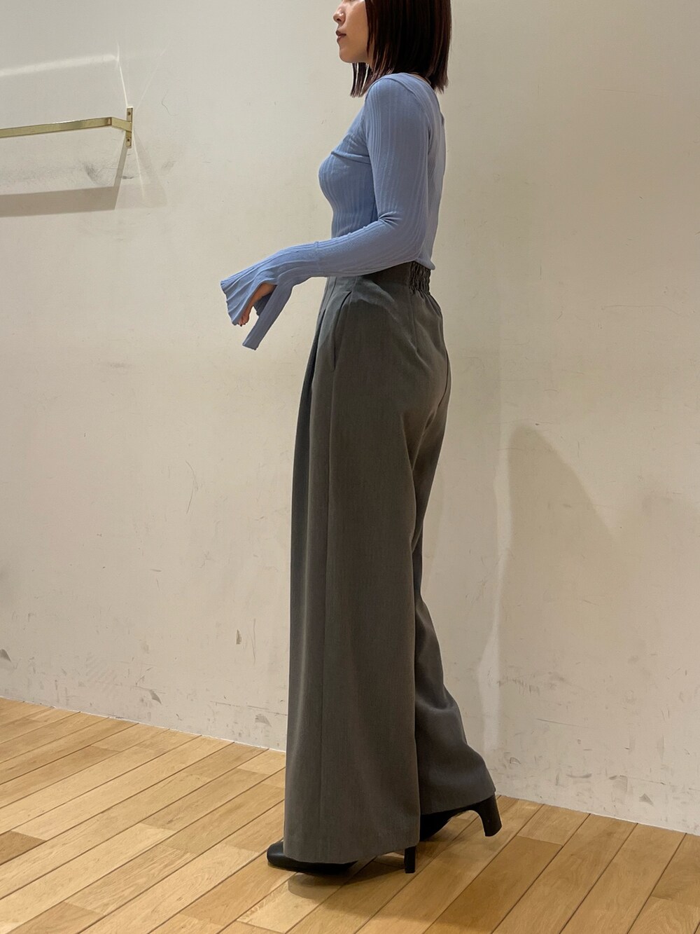グレー系のその他パンツ、ブルー系のニット/セーター、ブラック系のブーツを着用したレディースの冬コーディネートの2枚目の写真