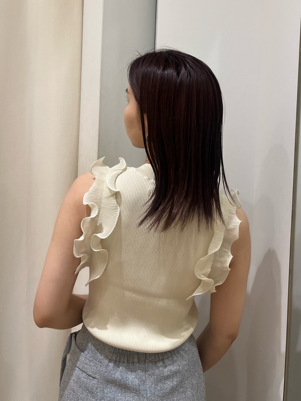 ホワイト系のニット/セーター、グレー系のスカート、ブラック系のサンダルを着用したレディースの夏コーディネートの6枚目の写真