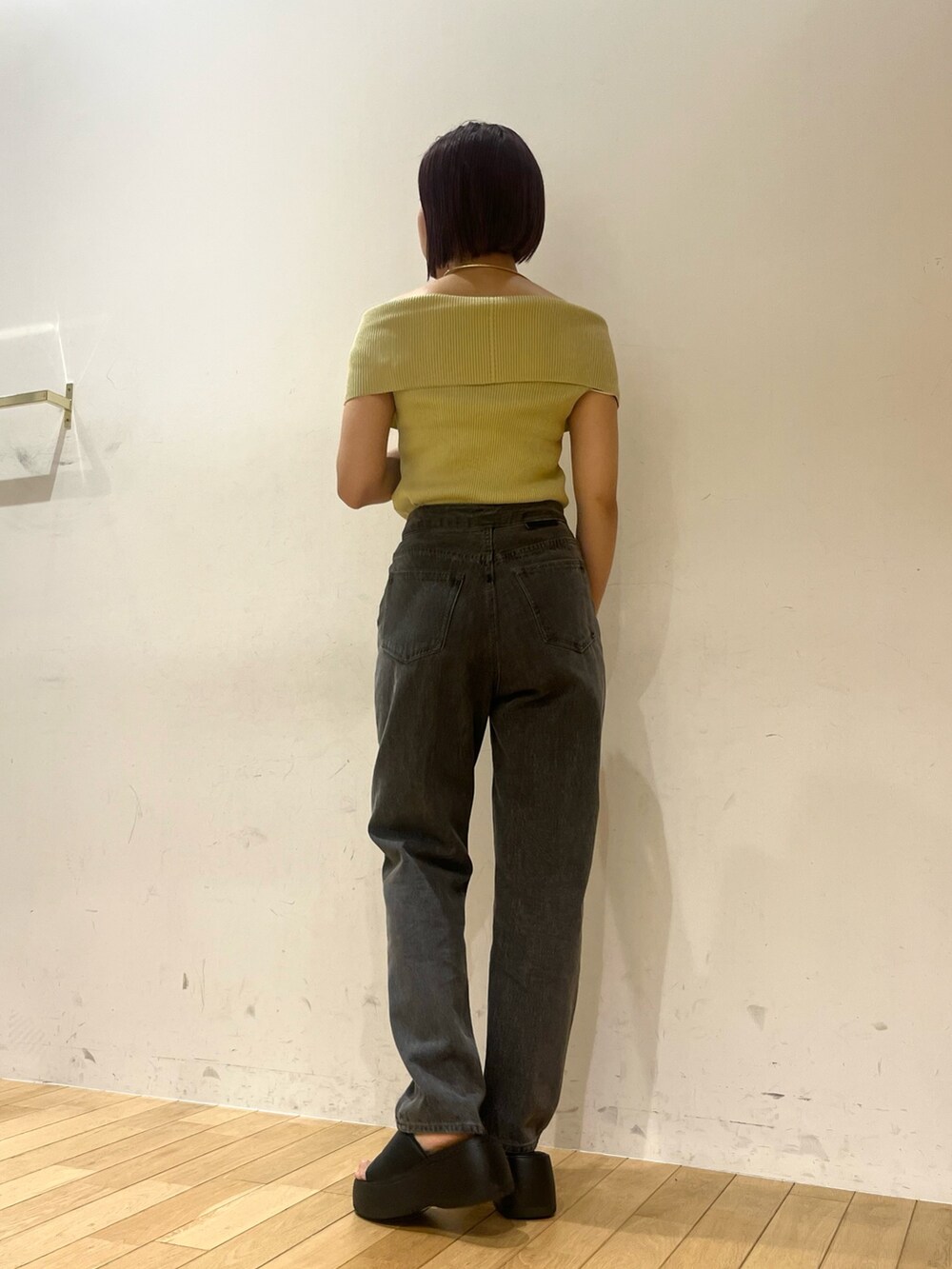 ブラック系のデニムパンツ、グリーン系のニット/セーターを着用したレディースの夏コーディネートの2枚目の写真