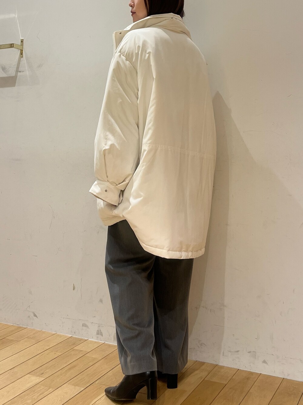 ブルー系のニット/セーター、グレー系のその他パンツ、ホワイト系のダウンジャケット/コートを着用したレディースの冬コーディネートの3枚目の写真