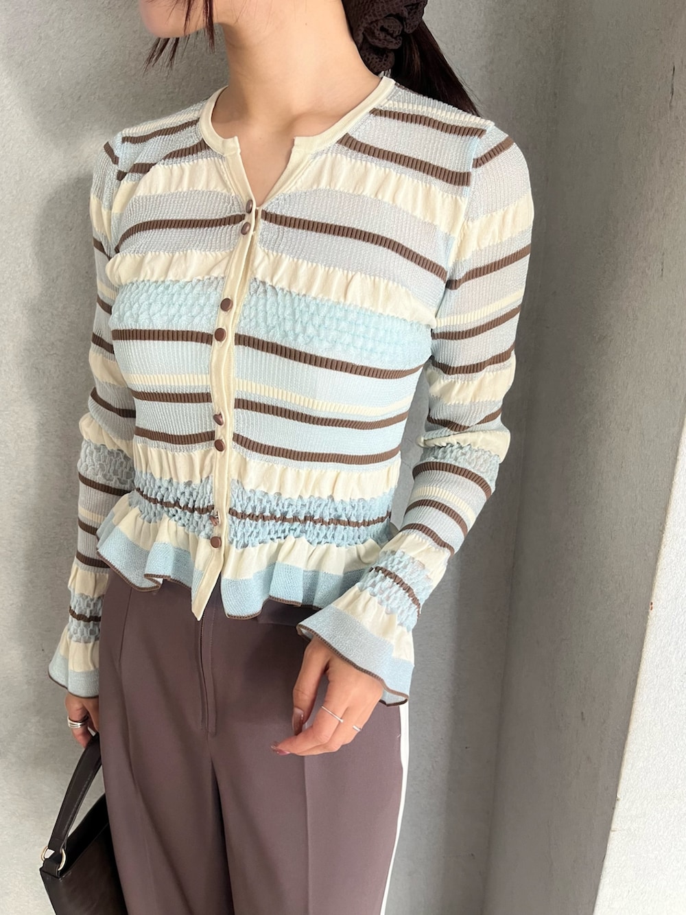 ブラウン系のハンドバッグ、ブラウン系のパンプス、ブラウン系のその他パンツを着用したレディースの冬コーディネートの6枚目の写真