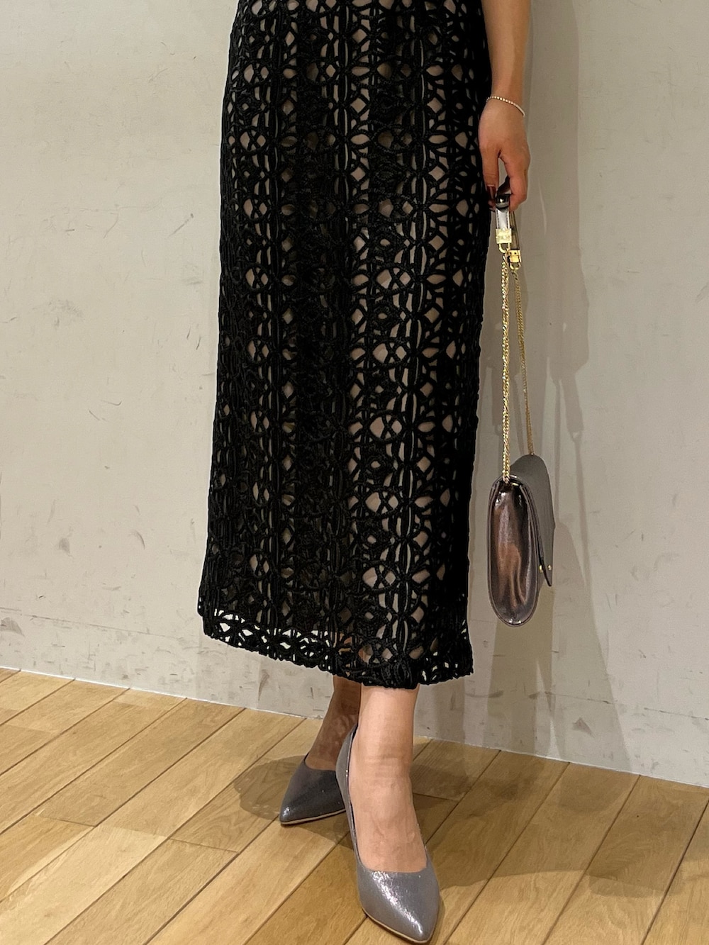 ブラック系のドレス、シルバー系のハンドバッグ、シルバー系のパンプスを着用したレディースの秋コーディネートの6枚目の写真