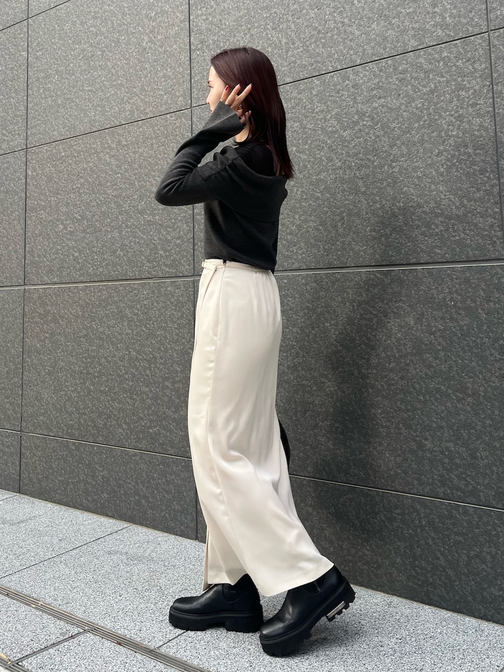 ホワイト系のスカート、ブラウン系のショルダーバッグ、ブラック系のニット/セーターを着用したレディースの冬コーディネートの2枚目の写真