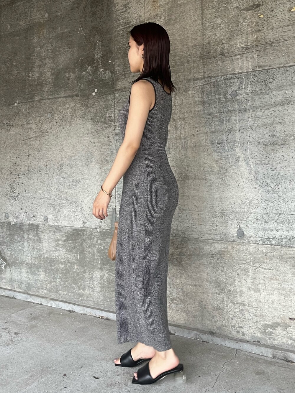 ブラック系のサンダル、グレー系のワンピース、ブラウン系のハンドバッグを着用したレディースの夏コーディネートの2枚目の写真