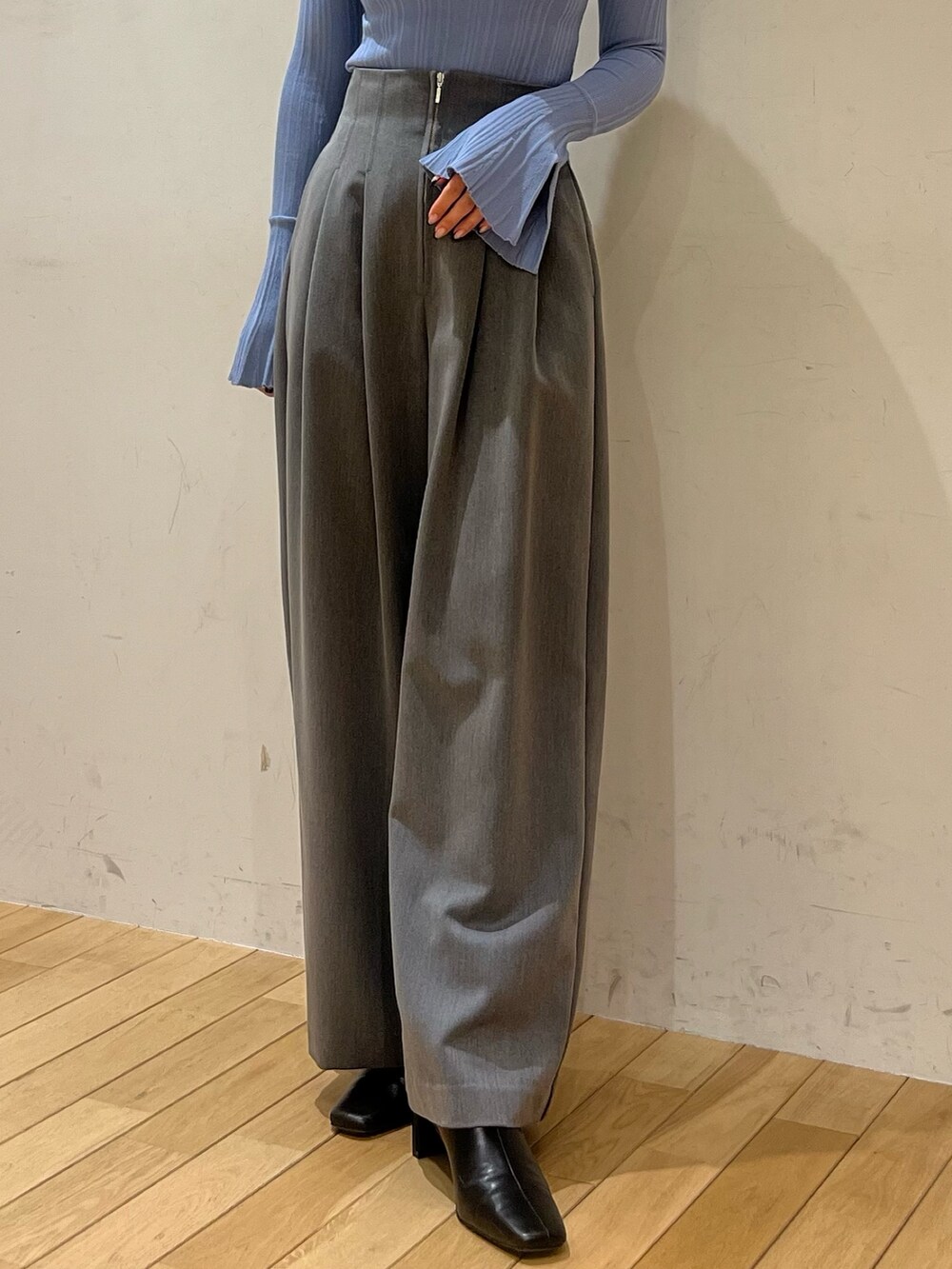 ブルー系のニット/セーター、グレー系のその他パンツ、ホワイト系のダウンジャケット/コートを着用したレディースの冬コーディネートの5枚目の写真