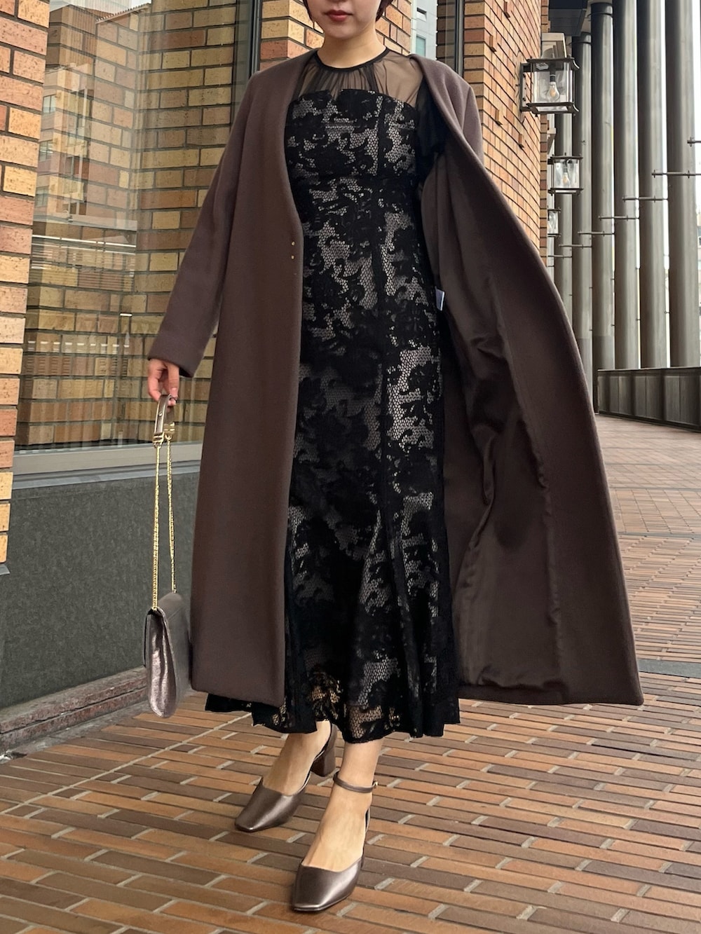 ブラック系のドレス、その他のパンプス、シルバー系のハンドバッグを着用したレディースの冬コーディネートの4枚目の写真