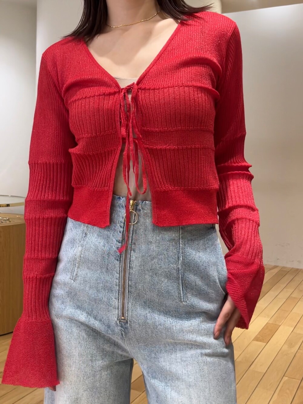 ブルー系のデニムパンツ、レッド系のカーディガン/ボレロ、ホワイト系のサンダルを着用したレディースの春コーディネートの4枚目の写真