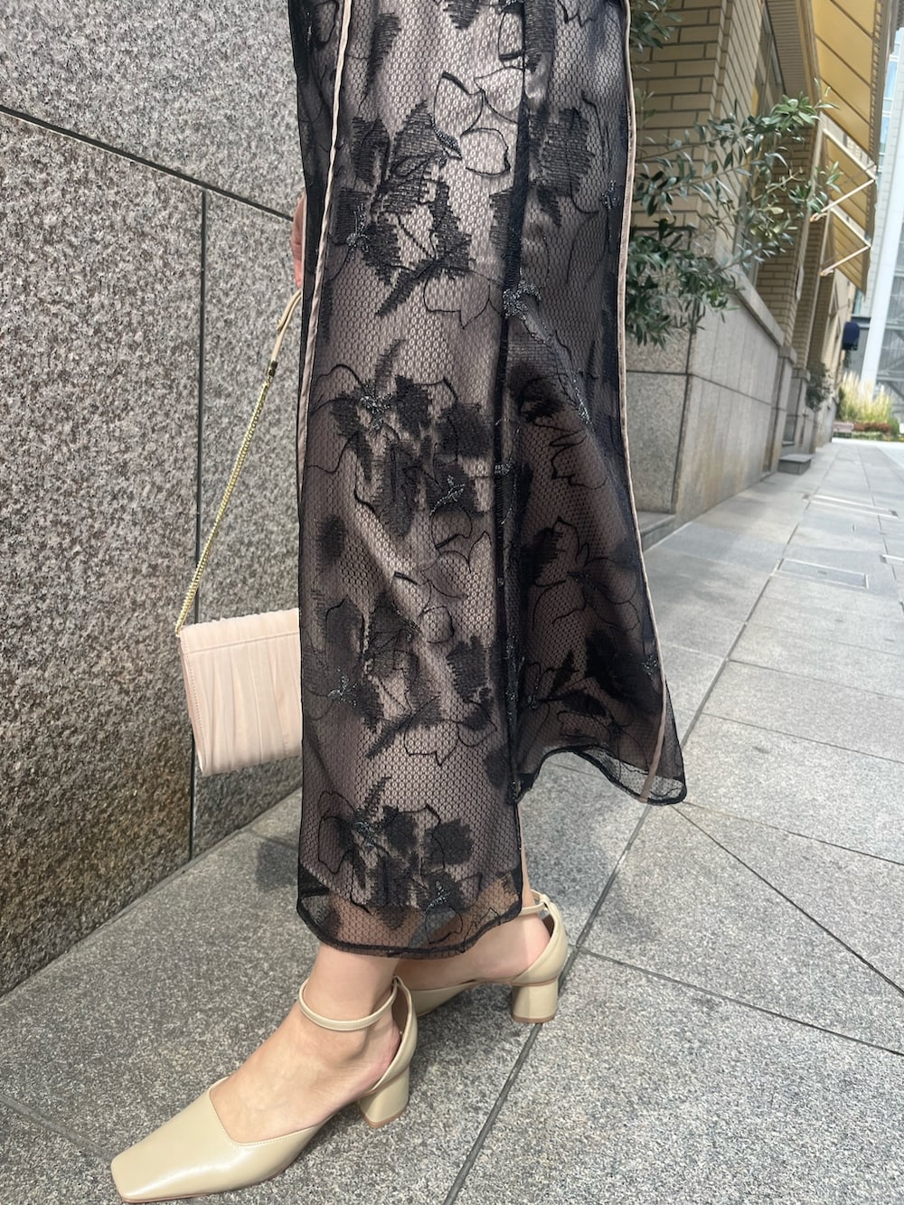 ベージュ系のパンプス、ベージュ系のハンドバッグ、ブラック系のドレスを着用したレディースの春コーディネートの6枚目の写真