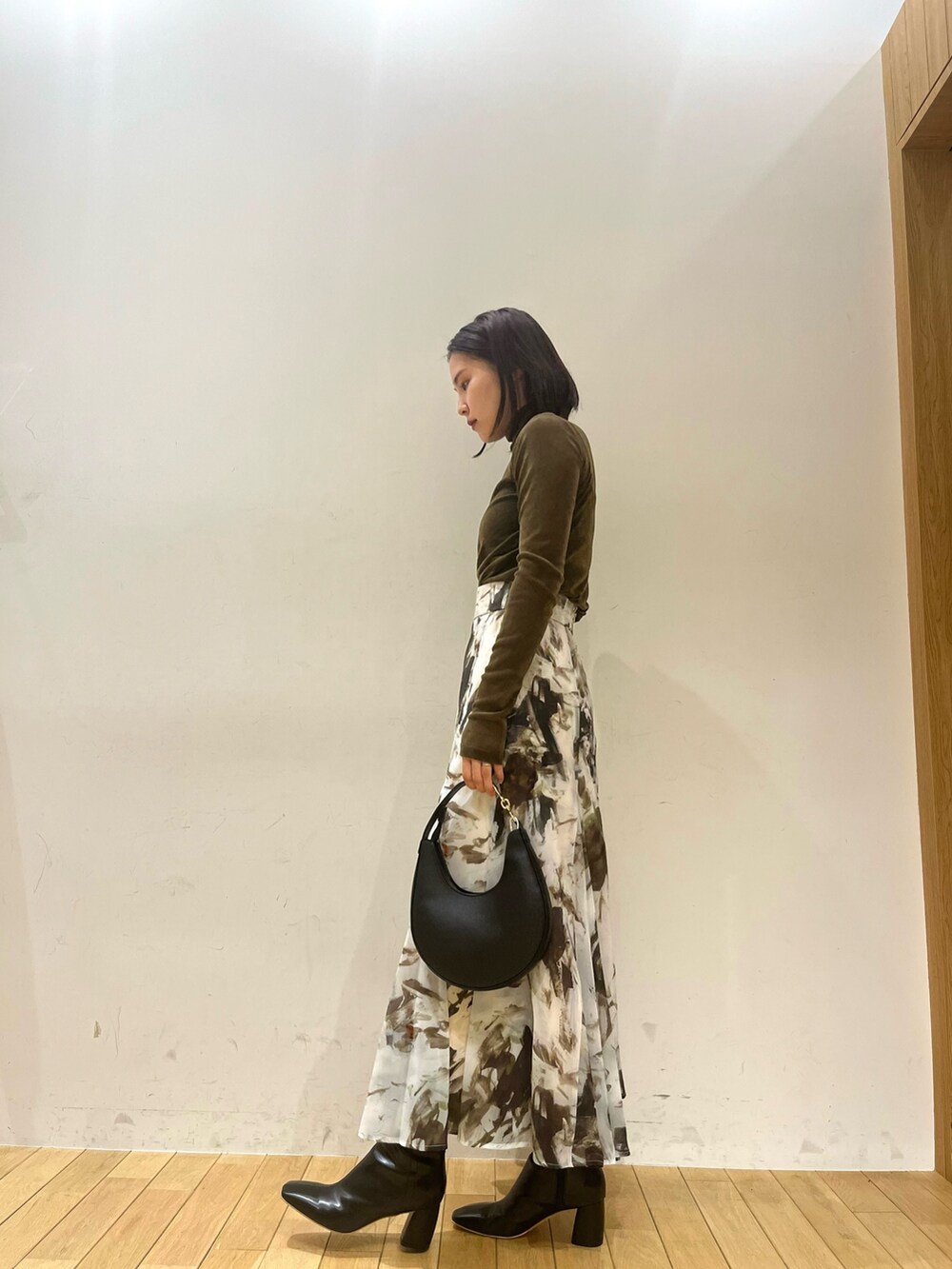 ベージュ系のテーラードジャケット、ブラウン系のTシャツ/カットソー、グリーン系のスカートを着用したレディースの秋コーディネートの4枚目の写真