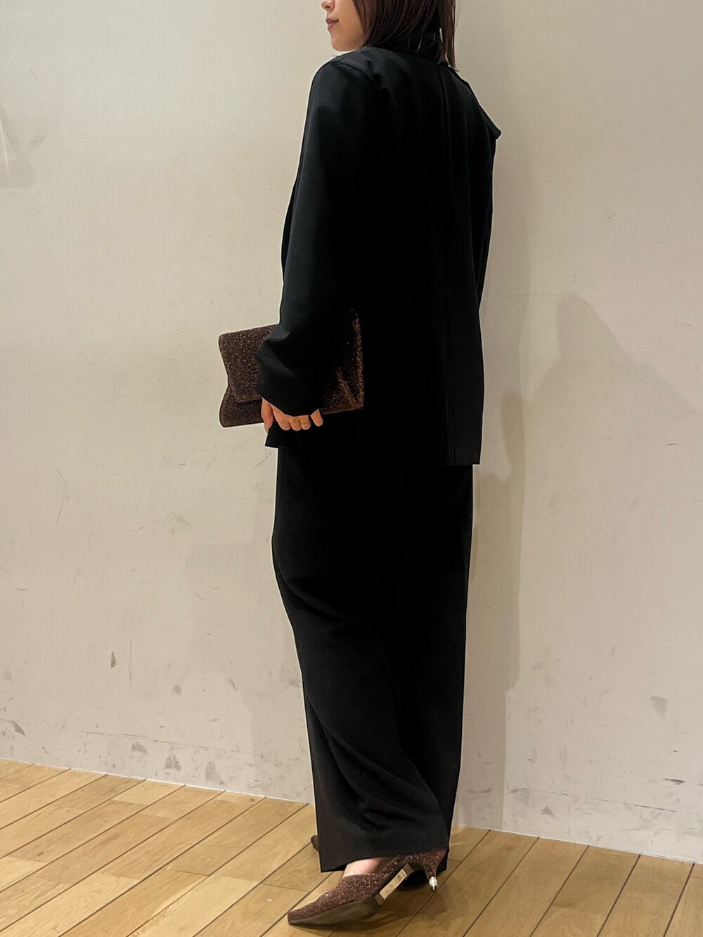 ホワイト系のTシャツ/カットソー、その他のクラッチバッグ、その他のパンプスを着用したレディースの冬コーディネートの3枚目の写真