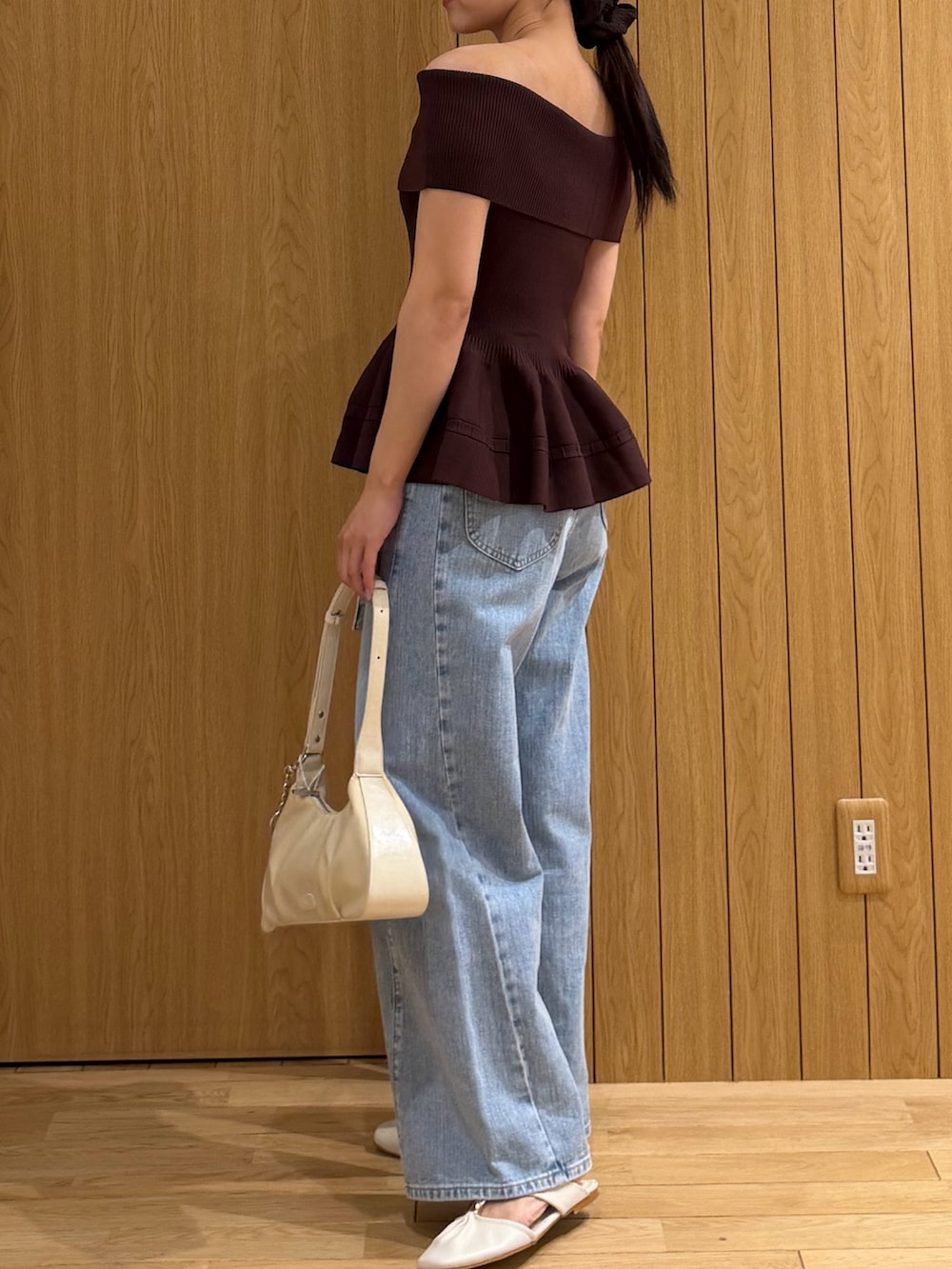 ブラウン系のニット/セーター、ブルー系のデニムパンツ、ホワイト系のハンドバッグを着用したレディースの夏コーディネートの2枚目の写真