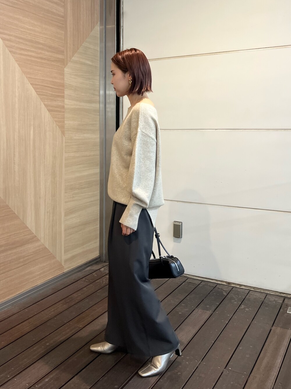 グレー系のその他パンツ、シルバー系のブーツ、ブラック系のショルダーバッグを着用したレディースの秋コーディネートの2枚目の写真