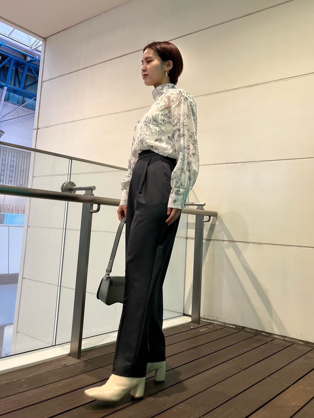 グレー系のシャツ/ブラウス、ブルー系のショルダーバッグ、グレー系のスラックスを着用したレディースの冬コーディネートの2枚目の写真