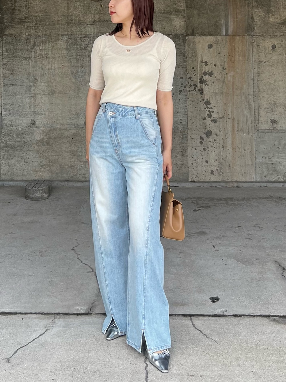 ブルー系のデニムパンツ、シルバー系のサンダル、ブラウン系のハンドバッグを着用したレディースの春コーディネートの6枚目の写真