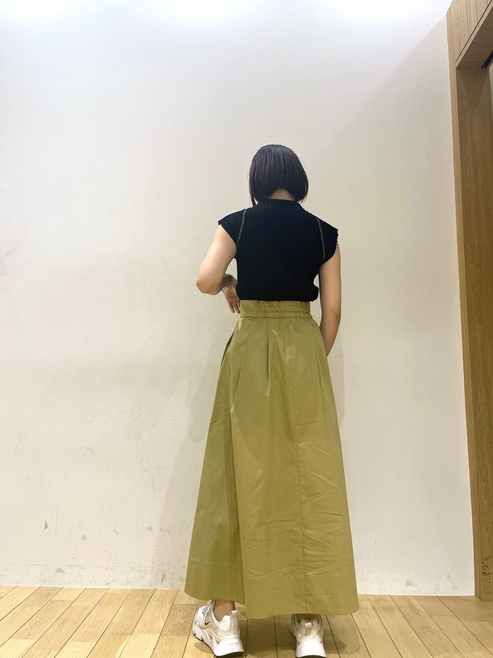ブラック系のニット/セーター、イエロー系のスカートを着用したレディースの夏コーディネートの3枚目の写真