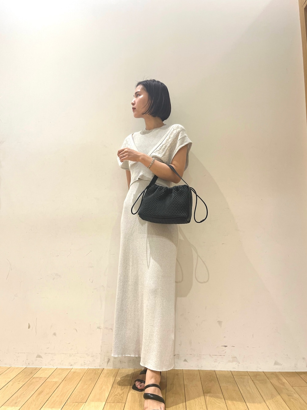 ベージュ系のハンドバッグ、ブルー系のワンピースを着用したレディースの夏コーディネートの2枚目の写真