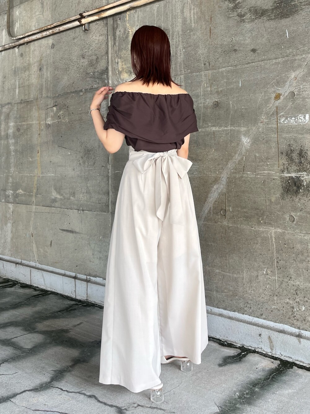 ブラウン系のシャツ/ブラウス、ブラウン系のハンドバッグ、ホワイト系のその他パンツを着用したレディースの夏コーディネートの3枚目の写真
