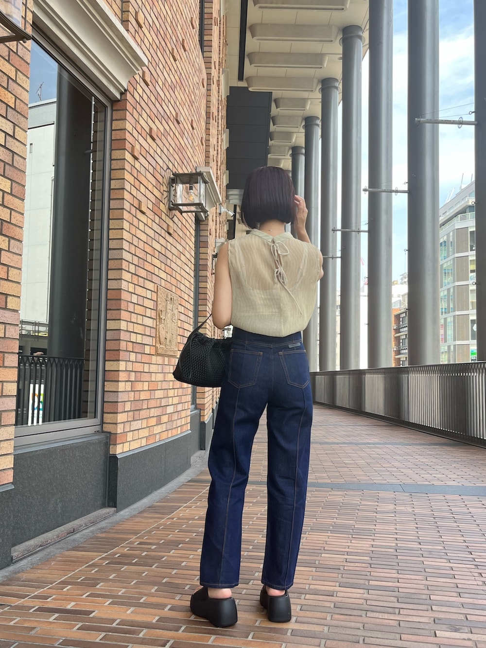 グリーン系のシャツ/ブラウス、ブルー系のデニムパンツ、ベージュ系のハンドバッグを着用したレディースの夏コーディネートの4枚目の写真