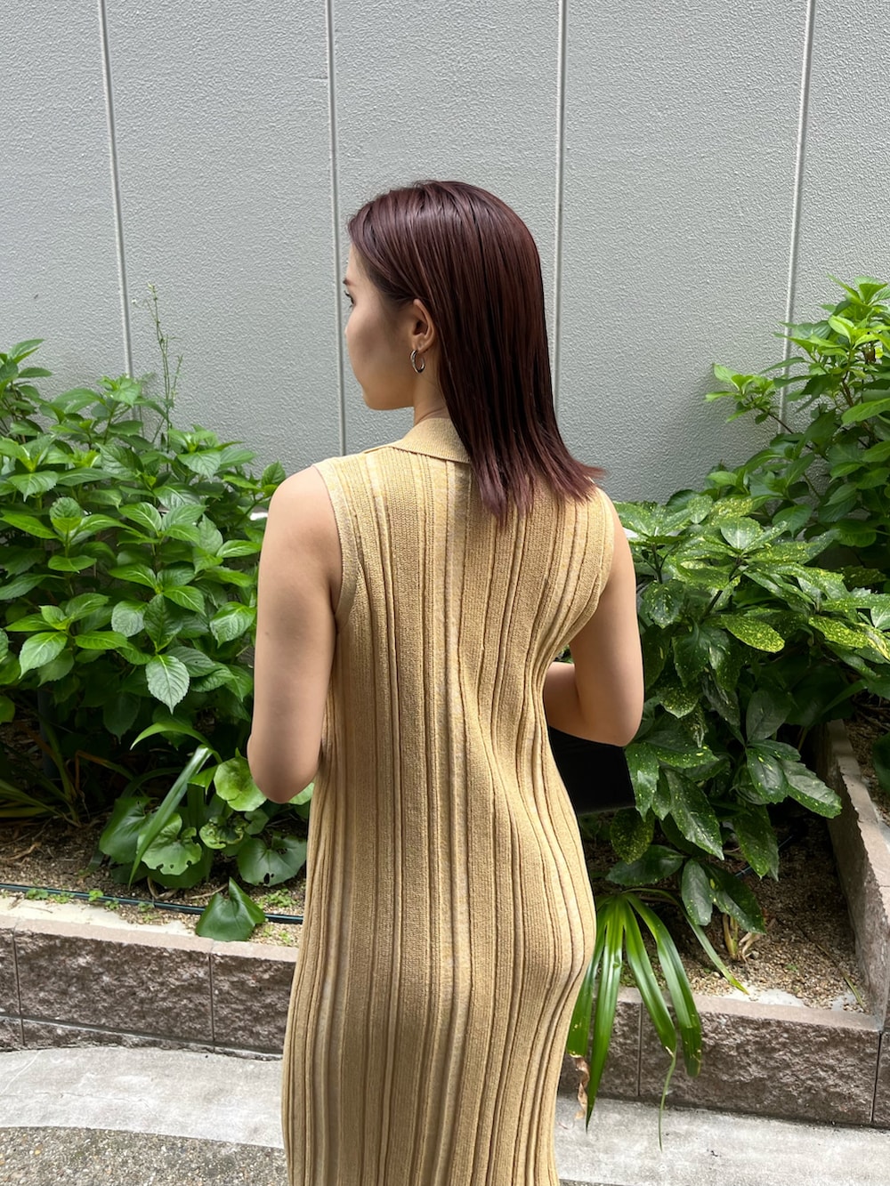 イエロー系のワンピース、ブラック系のハンドバッグ、ブラック系のサンダルを着用したレディースの夏コーディネートの7枚目の写真