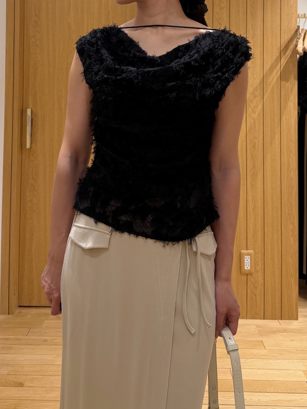 ブラック系のパンプス、ホワイト系のハンドバッグ、ブラック系のシャツ/ブラウスを着用したレディースの春コーディネートの4枚目の写真