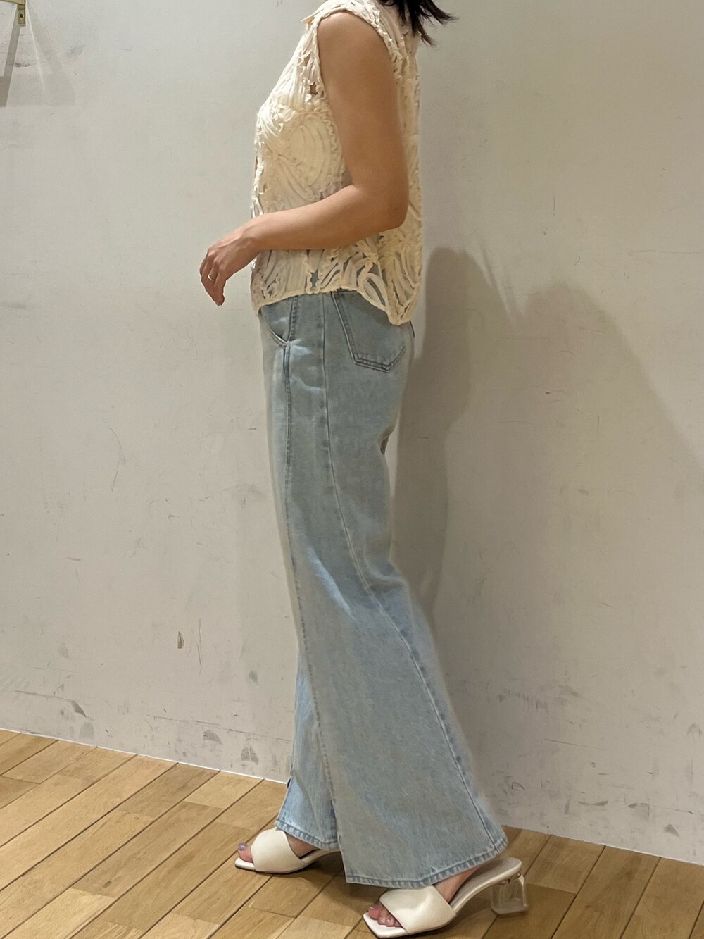 ブルー系のデニムパンツ、ホワイト系のシャツ/ブラウス、ホワイト系のサンダルを着用したレディースの夏コーディネートの2枚目の写真