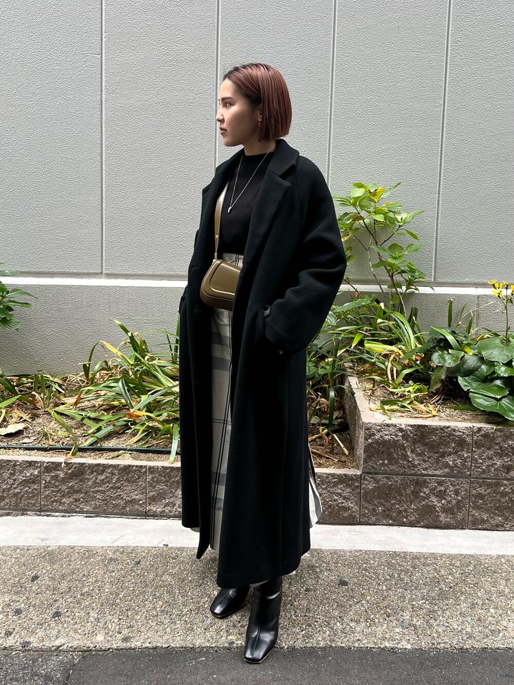 ホワイト系のワンピース、ブラック系のブーツ、ブラウン系のショルダーバッグを着用したレディースの冬コーディネートの4枚目の写真