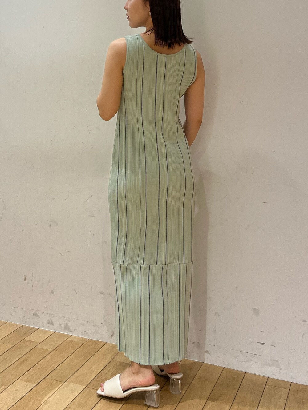 ホワイト系のサンダル、ホワイト系のテーラードジャケット、グリーン系のワンピースを着用したレディースの春コーディネートの3枚目の写真