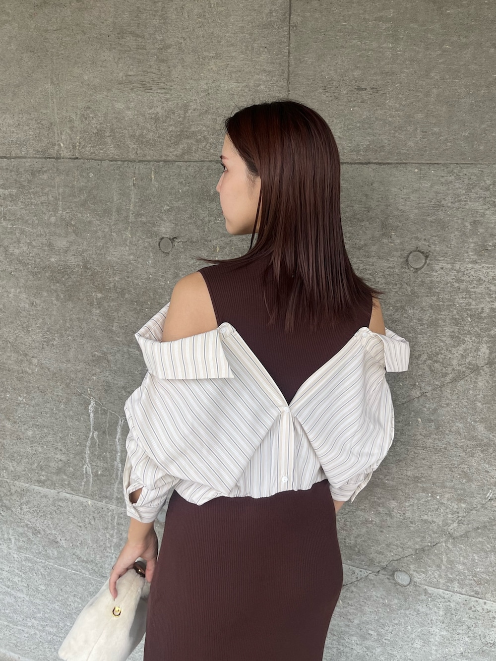 ブラウン系のパンプス、ホワイト系のハンドバッグ、ブラウン系のワンピースを着用したレディースの秋コーディネートの6枚目の写真