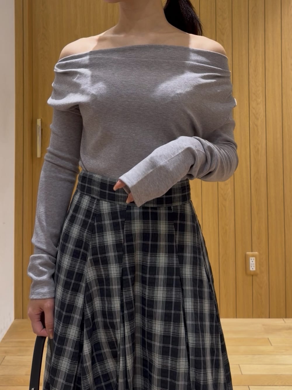 グレー系のTシャツ/カットソー、ブラック系のスカート、ブラック系のハンドバッグを着用したレディースの冬コーディネートの4枚目の写真