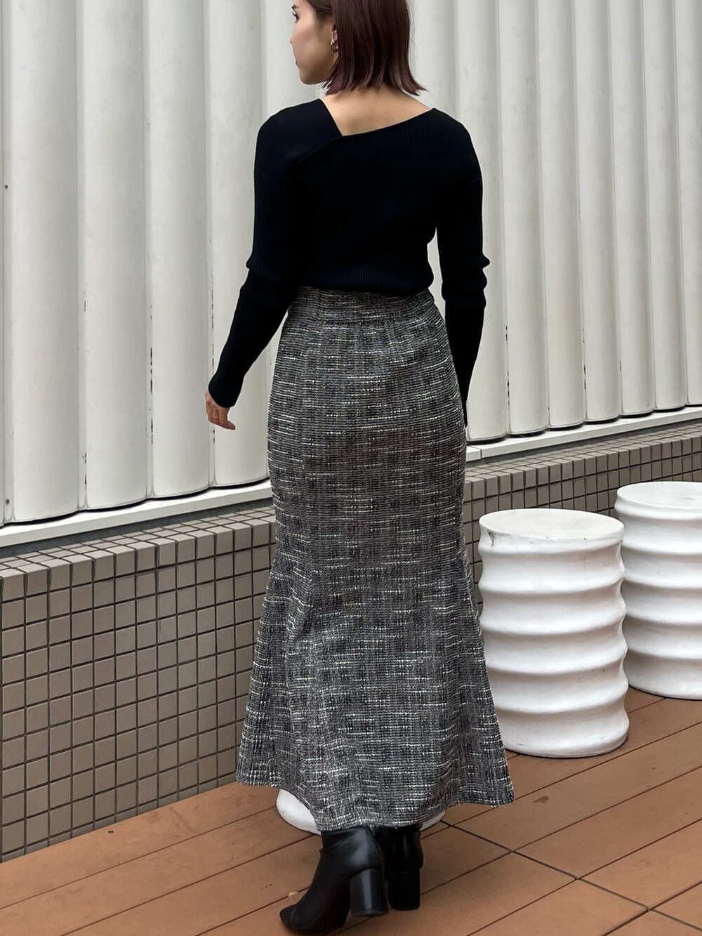 ブラック系のスカート、ブラック系のニット/セーターを着用したレディースの秋コーディネートの3枚目の写真