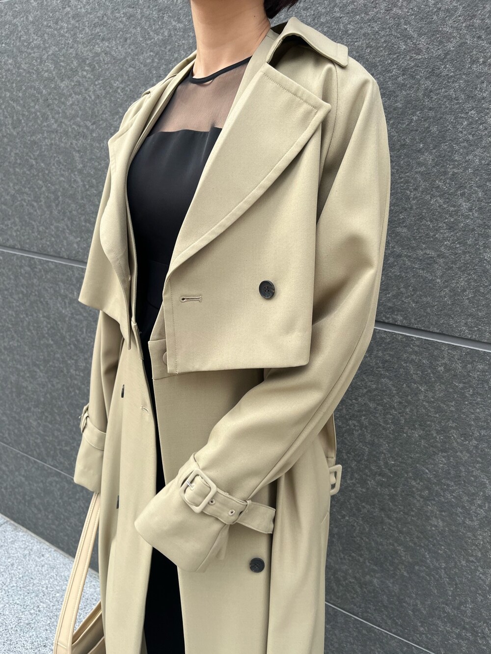 グリーン系のトレンチコート、シルバー系のパンプス、ブラック系のパンツドレスを着用したレディースの春コーディネートの6枚目の写真