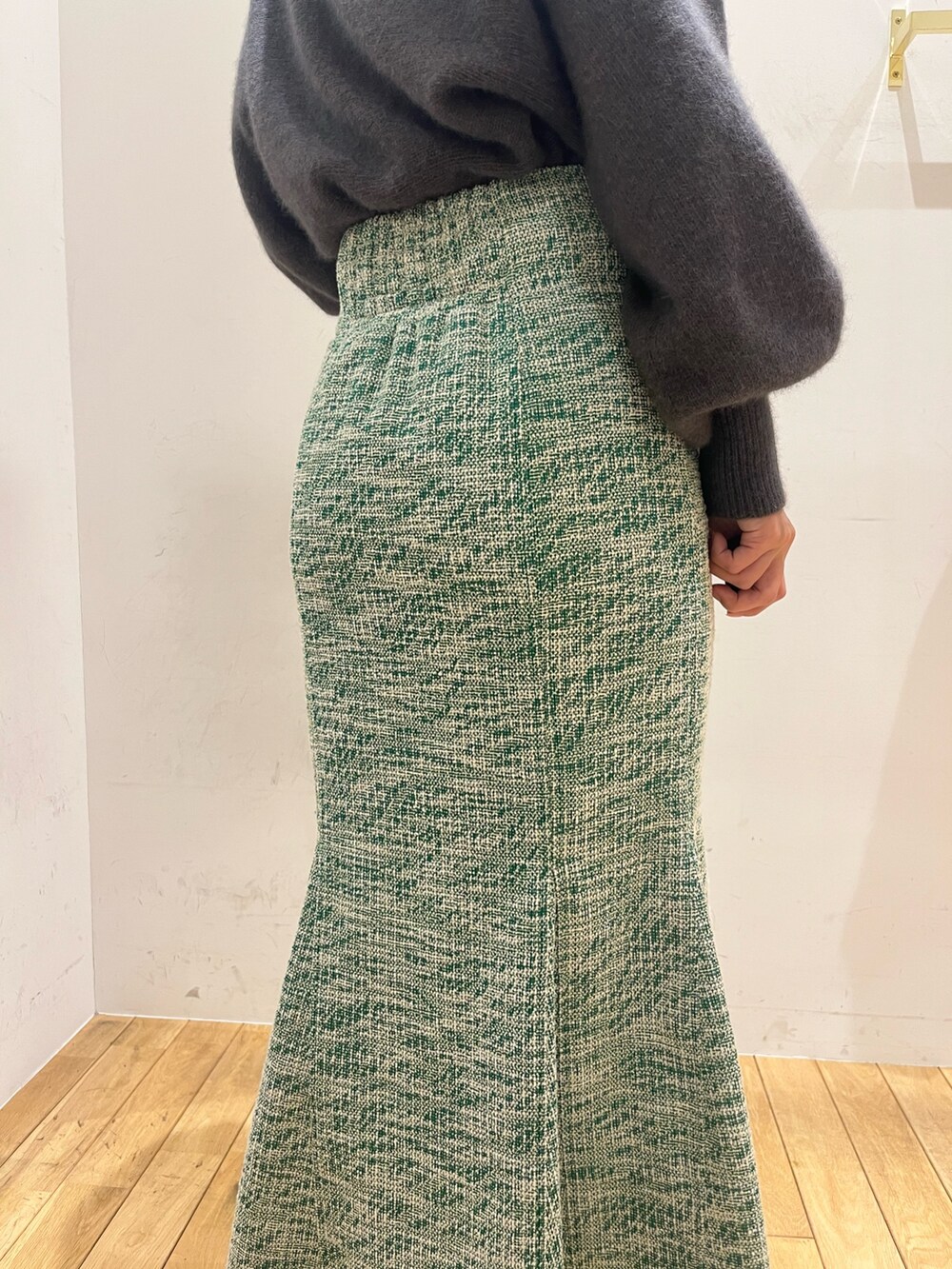 グレー系のニット/セーター、ブラック系のショルダーバッグ、ブラック系のブーツを着用したレディースの秋コーディネートの6枚目の写真